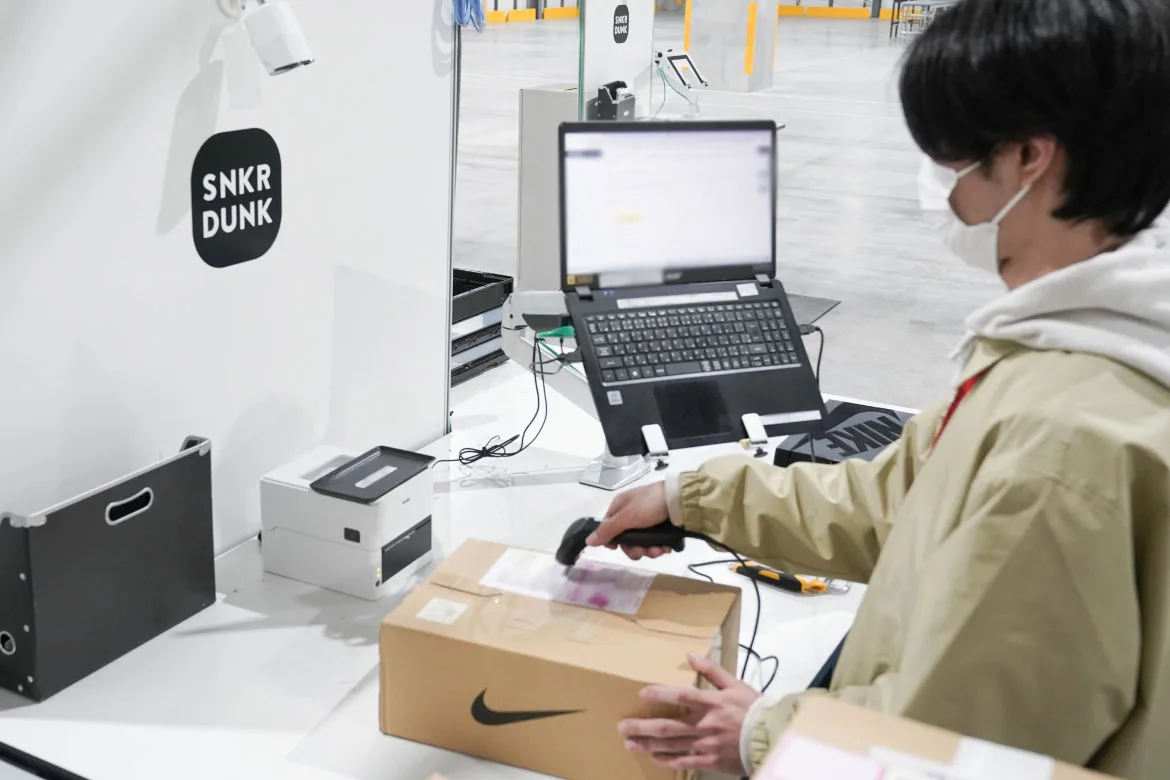 商品を丁寧に開封するスタッフの様子